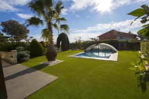 a garden with a palm tree and a swimming pool at Catalunya Casas A Cozy Catalan hideaway just 30min from Sitges! in Piera