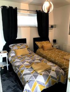 卡迪根的住宿－Katy’s Cwtch，两张睡床彼此相邻,位于一个房间里