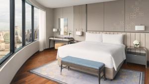 a bedroom with a large bed and a large window at InterContinental Bangkok by IHG in Bangkok