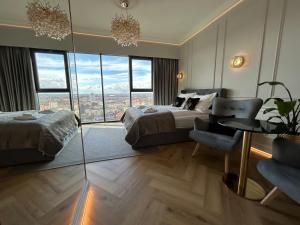 um quarto com uma cama e uma mesa e algumas janelas em Hanza Tower HOME4U em Szczecin