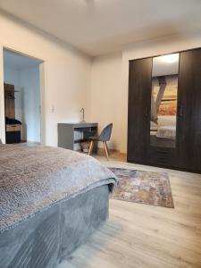 Schlafzimmer mit einem Bett, einem Schreibtisch und einem Spiegel in der Unterkunft Stilvolles Appartement in Bielefeld