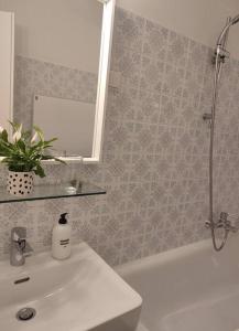 a bathroom with a sink and a bath tub with a mirror at Studio mit Terrasse in zentraler Lage in Graz
