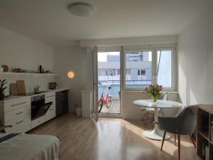 a room with a bed and a table and a kitchen at Studio mit Terrasse in zentraler Lage in Graz