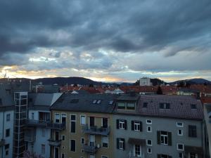 a view of a city with buildings and a cloudy sky at Studio mit Terrasse in zentraler Lage in Graz