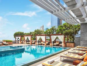 a swimming pool with lounge chairs and a hotel at Four Seasons Hotel Mumbai in Mumbai