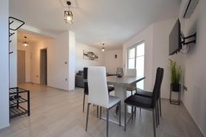 a dining room and living room with a table and chairs at Apartment Lana in Soline