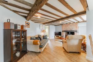 a living room with a couch and two chairs at Bar Lane Cottage - Norfolk Cottage Agency in Reepham