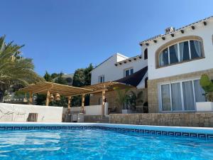 a villa with a swimming pool in front of a house at Casa El Sueño in Jávea