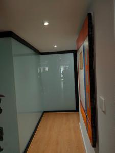 a hallway with a glass door and a wooden floor at La Paz in Almansa