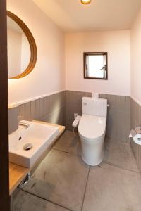 Łazienka z białą toaletą i umywalką w obiekcie PICNIC　GARDEN w mieście Awaji