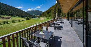 um pátio com mesas e cadeiras numa varanda em Gasthof Rabenstein em Sarentino