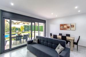 a living room with a couch and a dining room at Catalunya Casas Modern Vacation Paradise 'Villa Ainmi' on the Costa Brava! in Sils