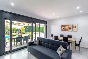 Una sala de estar con un sofá y un comedor. en Catalunya Casas Modern Vacation Paradise 'Villa Ainmi' on the Costa Brava!, en Sils