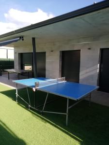 un tavolo da ping pong blu di fronte a un edificio di Catalunya Casas Modern Vacation Paradise 'Villa Ainmi' on the Costa Brava! a Sils