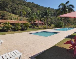a swimming pool with two chairs and a house at Solo Sagrado in Bom Jardim