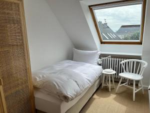 a small bedroom with a bed and a window at Haus Janus 3 - Wohnung 4 in Norderney