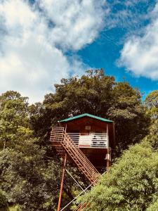 une cabane dans les arbres sur le flanc d'une colline dans l'établissement The Cocoon Camps & nature Resorts, à Nainital