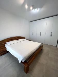 a bedroom with a large bed and white cabinets at Villetta Pima in Garda