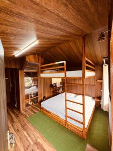 Cette chambre en bois comprend des lits superposés. dans l'établissement The Cocoon Camps & nature Resorts, à Nainital