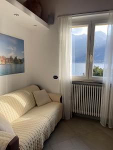 a living room with a couch and a large window at Casa delle Olive 1 in Oliveto Lario