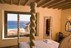 a bedroom with a bed with a view of the ocean at Aegea Blue Cycladic Resort in Zorgos 