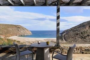 a table and chairs on a patio with a view of the ocean at Aegea Blue Cycladic Resort in Zorgos 