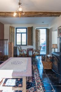 a living room with a fireplace and a table at Maisons de vacances Le Vieux Marronnier in Dinant