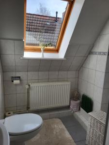 a bathroom with a toilet and a window at Westküste Ferienwohnung in Heide +23 photos
