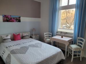 a bedroom with a bed and a table and a window at Ferienwohnung Mira in Cottbus