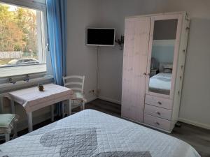 a bedroom with a bed and a dresser with a mirror at Ferienwohnung Mira in Cottbus