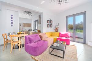 a living room with a purple couch and a table at Mythos Luxury Villa-Skiathos in Troulos