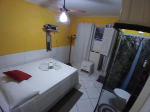 1 dormitorio con cama blanca y pared amarilla en Chapada Casas da Izete, en Lençóis