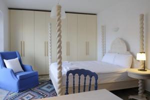 a bedroom with a bed and a blue chair at Aegea Blue Cycladic Resort in Zorgos 