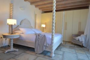 a bedroom with a white bed and a table and lamp at Aegea Blue Cycladic Resort in Zorgos 