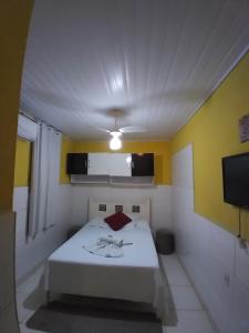 a small room with a bed and a tv at Chapada Casas da Izete in Lençóis