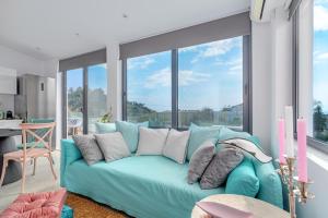 a living room with a blue couch in front of a window at Mythos Luxury Villa-Skiathos in Troulos