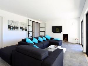 a living room with a black couch and blue pillows at Luxurious Algarve Villa Villa Manou 5 Bedrooms Private Heated pool 300m from the Beach Carvoeiro in Carvoeiro