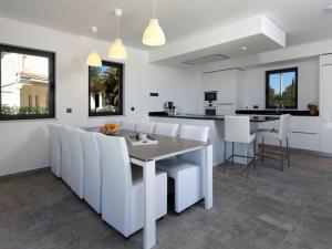 a white kitchen with a table and white chairs at Luxurious Algarve Villa Villa Manou 5 Bedrooms Private Heated pool 300m from the Beach Carvoeiro in Carvoeiro