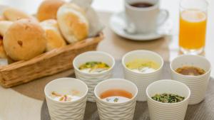 una mesa con tazas de sopa y una cesta de pan en Toyoko Inn Kofu eki Minami guchi No 1 en Kofu