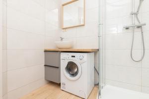 a bathroom with a washing machine and a sink at Liliowa Seaside Apartments by Renters in Dębki