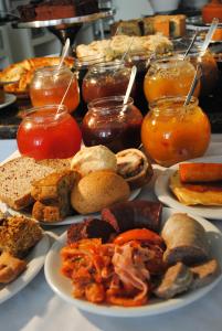 a table with plates of food and jars of jam at Hotel Rieger in Balneário Camboriú