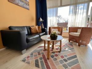salon z kanapą i stołem w obiekcie Reumann Holiday Apartments: De Schelp w Zandvoort