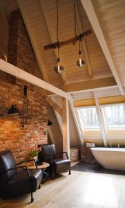 a living room with a brick wall and a ceiling with skylights at Fließ Paradies mit Blockbohlensauna in Leipe