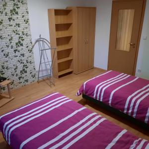 2 camas en una habitación con sábanas moradas y blancas en Ferienwohnung Branitz, en Cottbus