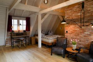 a bedroom with a bed and a desk in a attic at Ferienhaus Fließ Paradies mit privatem Saunahaus - Leipe, Spreewald in Leipe