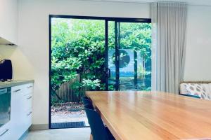 a kitchen with a wooden counter and a large window at Designer Studio in Sydney