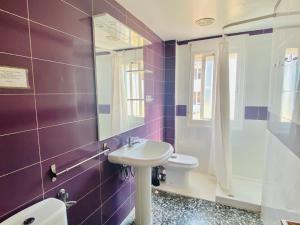 Baño púrpura con lavabo y espejo en CHALET BLAU MAR, en Peñíscola