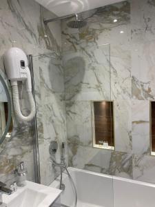 a bathroom with a shower and a sink at Park Avenue Hotel in London