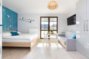 a bedroom with a bed and a table and a couch at Liliowa Seaside Apartments by Renters in Dębki