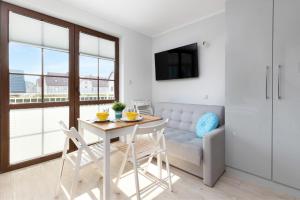 a living room with a table and chairs and a couch at Liliowa Seaside Apartments by Renters in Dębki